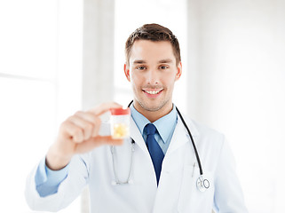 Image showing male doctor with jar of capsules