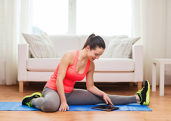 Image showing smiling teenage girl streching on floor at home