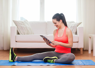 Image showing smiling teenage girl streching on floor at home