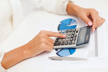 Image showing businesswoman working with calculator in office