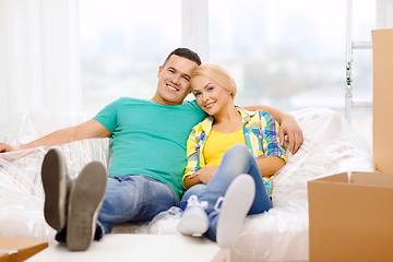 Image showing smiling couple relaxing on sofa in new home