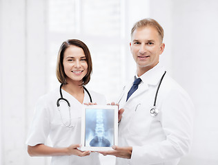 Image showing two doctors showing x-ray on tablet pc