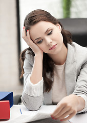 Image showing bored and tired woman behid the table