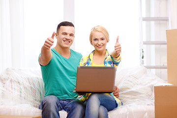 Image showing couple relaxing on sofa with laptop in new home