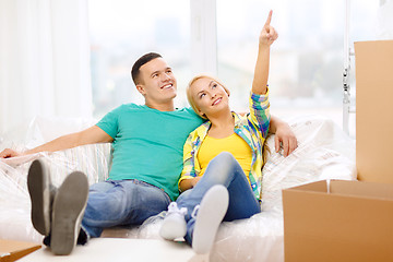 Image showing smiling couple relaxing on sofa in new home