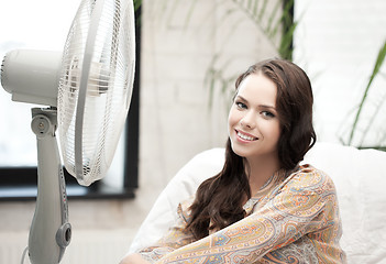 Image showing happy and smiling woman sitting near ventilator