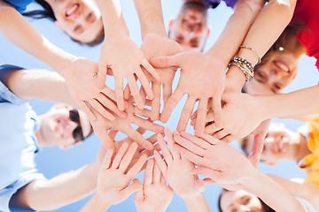 Image showing teenagers hands on top of each other outdoors