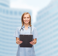 Image showing smiling female doctor or nurse with clipboard