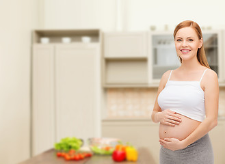 Image showing happy future mother touching her belly