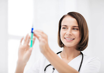 Image showing female doctor holding syringe with injection