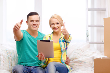 Image showing couple relaxing on sofa with tablet pc in new home