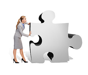 Image showing busy businesswoman pushing puzzle piece