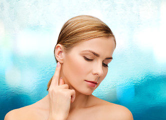 Image showing calm woman touching her ear