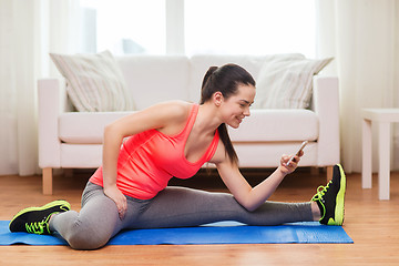 Image showing smiling teenage girl streching on floor at home