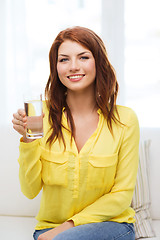 Image showing smiling teenager with glass of water at home