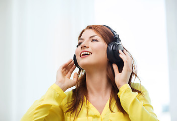 Image showing smiling young girl in headphones at home