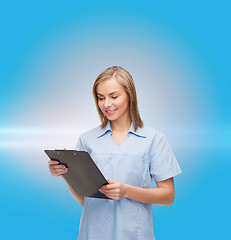 Image showing smiling female doctor or nurse with clipboard