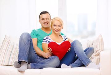 Image showing smiling happy couple with red heart at home