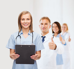 Image showing smiling female doctor or nurse with clipboard