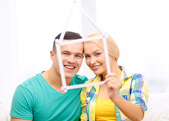 Image showing smiling couple with house from measuring tape