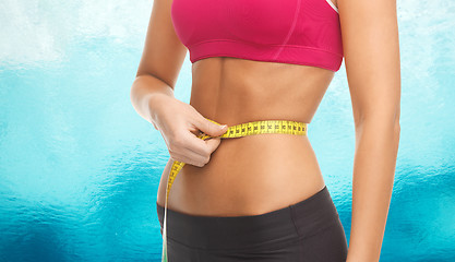 Image showing close up trained belly with measuring tape