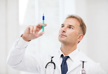 Image showing male doctor holding syringe with injection