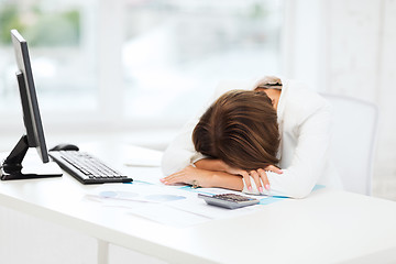 Image showing stressed woman with computer, papers, calculator