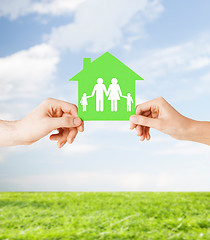 Image showing hands holding green house with family