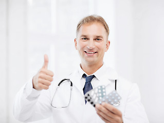 Image showing male doctor with packs of pills