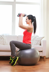 Image showing smiling girl exercising with fitness ball