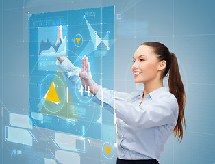 Image showing smiling businesswoman working with virtual screen