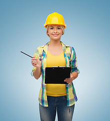 Image showing smiling woman in helmet with clipboard