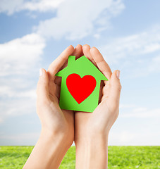 Image showing hands holding green paper house