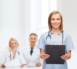 Image showing smiling female doctor or nurse with clipboard