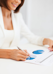 Image showing businesswoman working with graphs in office