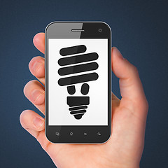 Image showing Finance concept: Energy Saving Lamp on smartphone