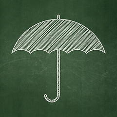 Image showing Protection concept: Umbrella on chalkboard background