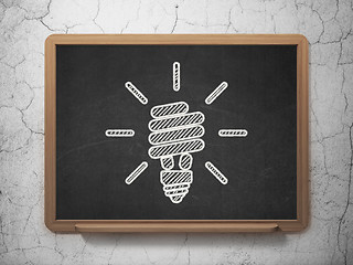 Image showing Finance concept: Energy Saving Lamp on chalkboard background