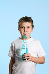 Image showing Thirsty boy drinking water
