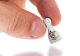 Image showing Hand holding wooden pawn, flag painting, selective focus