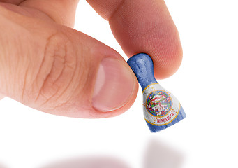 Image showing Hand holding wooden pawn, flag painting, selective focus