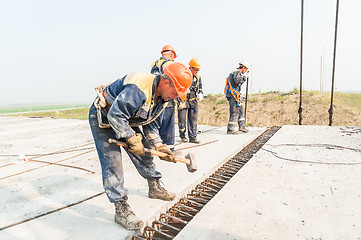 Image showing Workers mount bridge span.