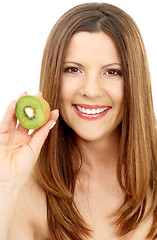 Image showing beautiful brunette showing fresh kiwi