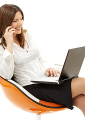 Image showing businesswoman with laptop and phone in orange chair