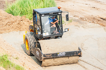 Image showing Road roller compressing sand to highway