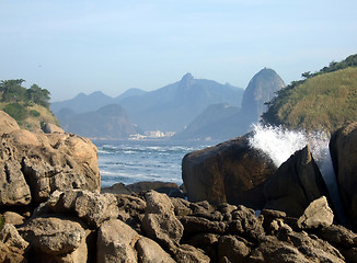 Image showing Rocks on the beach, with Christ Redeemer statue, one of the new seven wonders of the world, in the background
