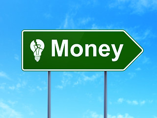 Image showing Business concept: Money and Light Bulb on road sign background