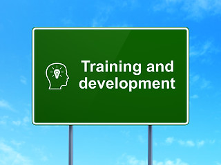 Image showing Education concept: Training and Development and Head With Lightbulb on road sign background