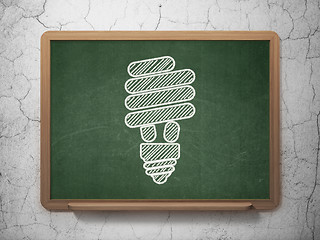 Image showing Finance concept: Energy Saving Lamp on chalkboard background