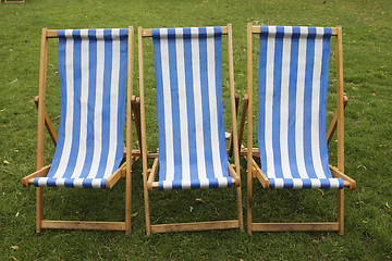 Image showing blue and white stripped empty deckchairs